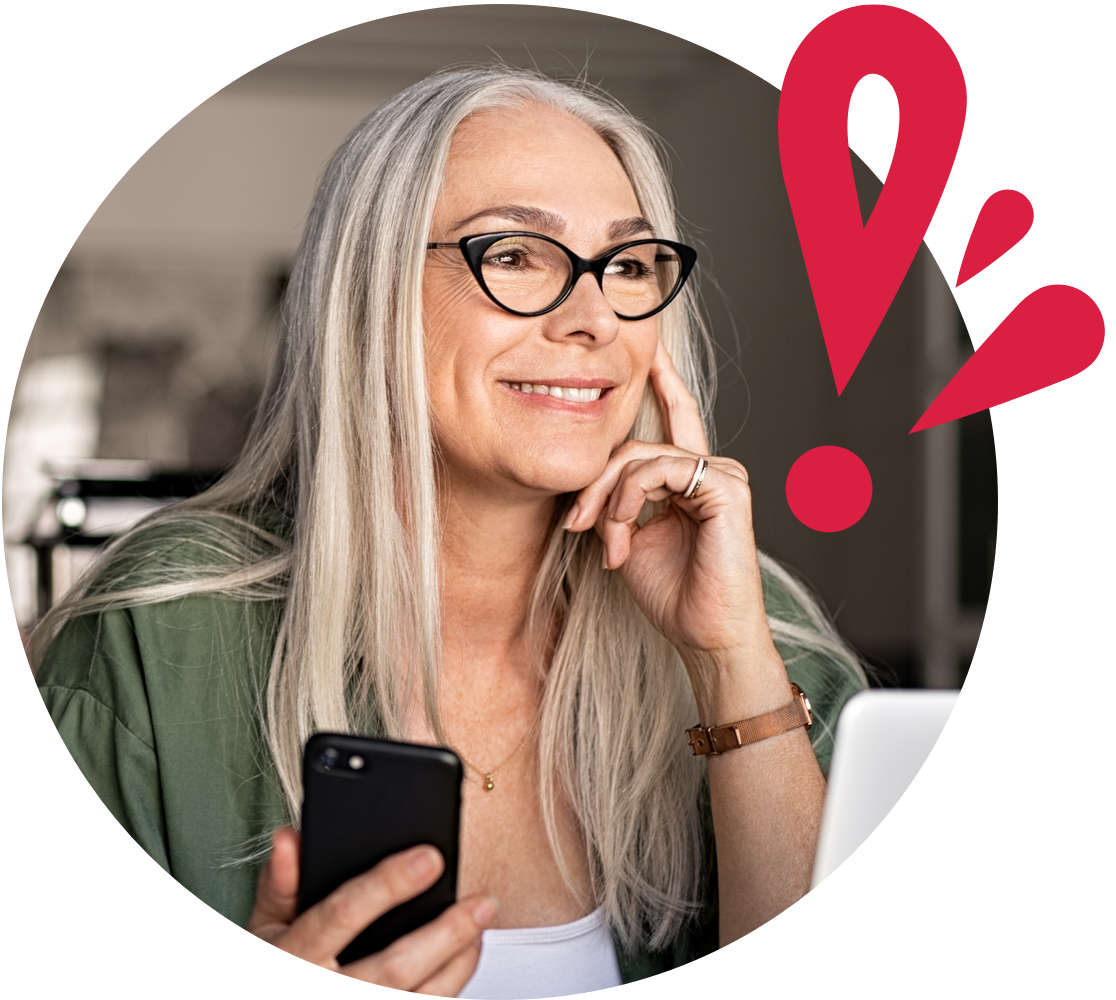 Older woman smiling and looking off screen while holding cell phone